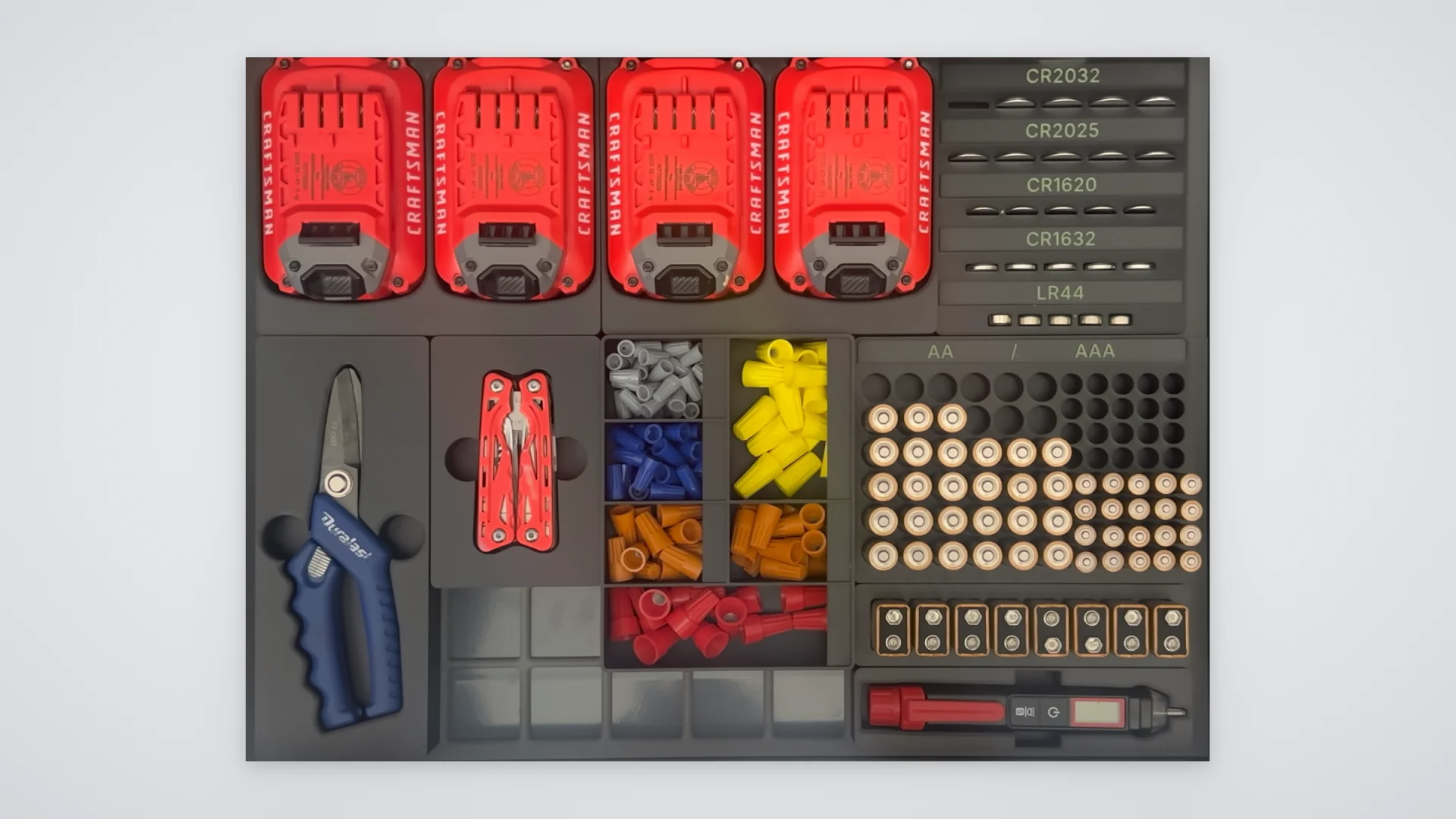 A full drawer of Gridbox Pro bins and shadowboxes holding drill batteries, coin cells, snips, a multitool, wire nuts and batteries