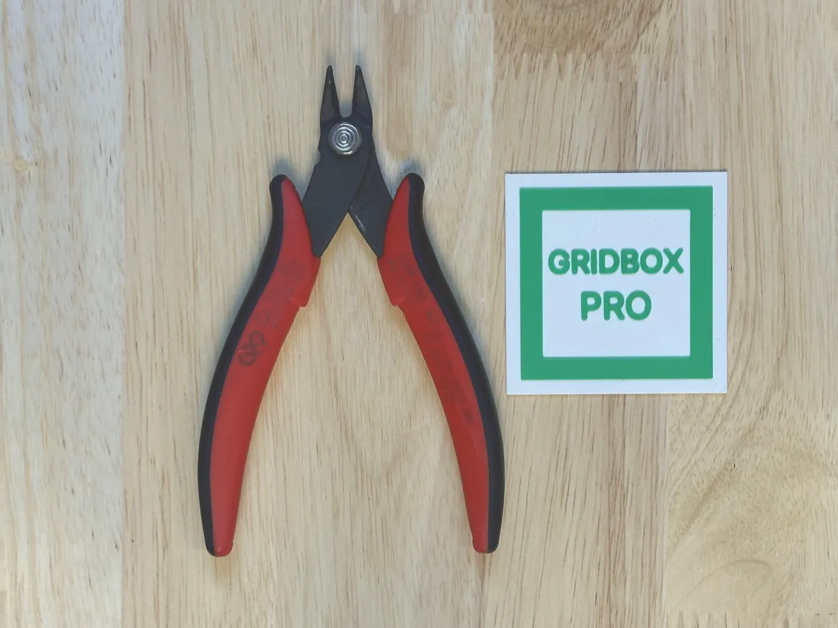 Wire cutters lying next to the printed scaler tile, photographed from straight above